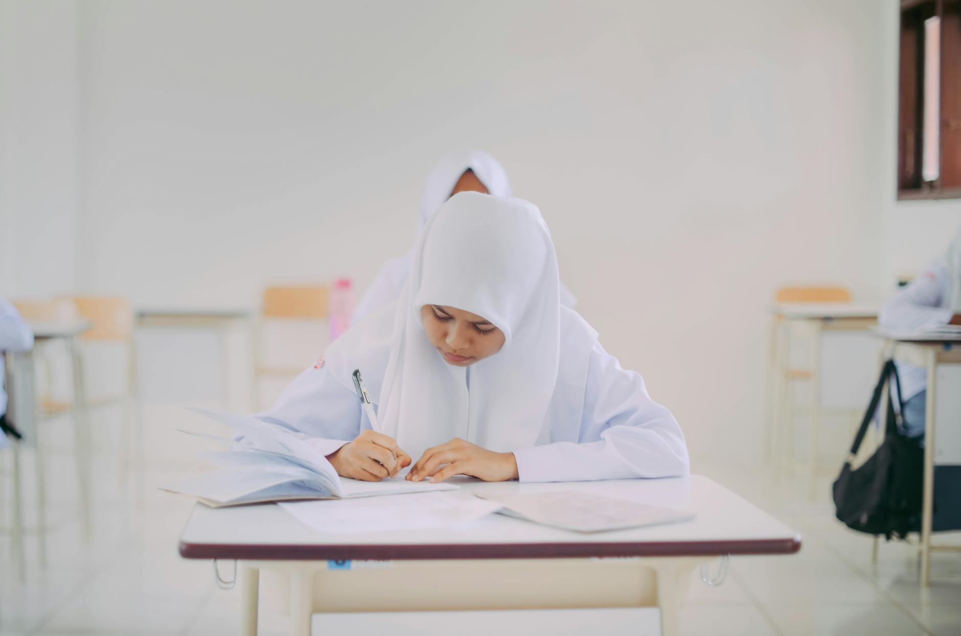 Papan nama "Pengembangan Sekolah" di depan gedung sekolah modern, menunjukkan fokus pada peningkatan kualitas pendidikan.